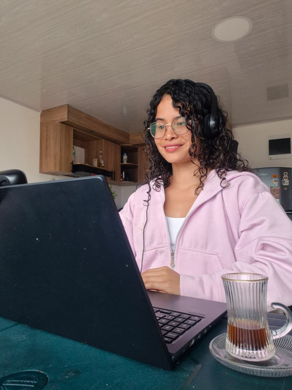 Profesora de español dando una clase en línea desde casa, frente a su portátil